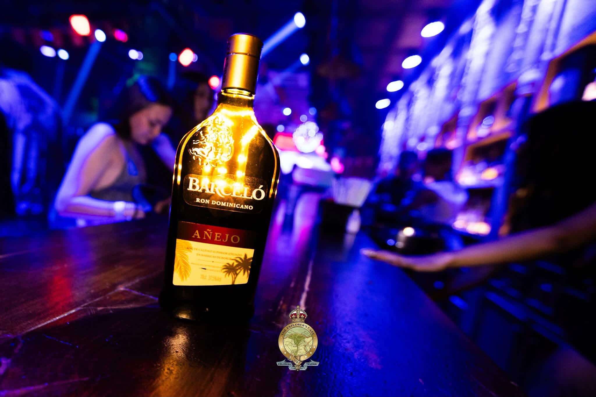 Detalle de botella en barra con luces de neón azul